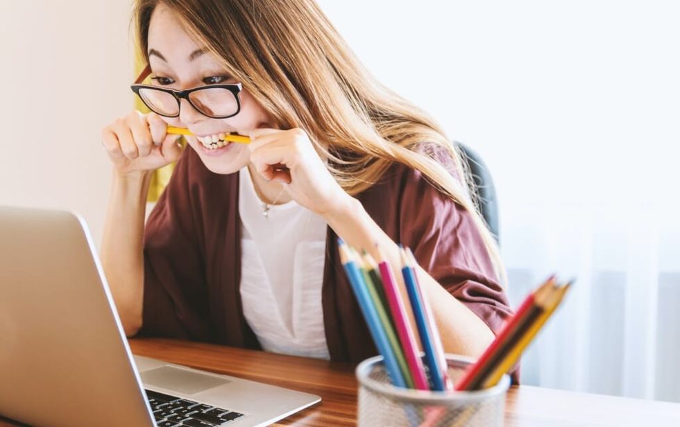 young woman stuggles with stress sitting at desk