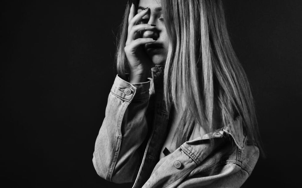 young woman suffers with hand on face