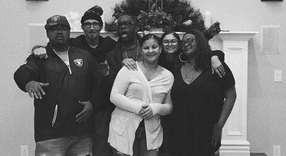 Zendaya posing with her siblings in black and white photo.