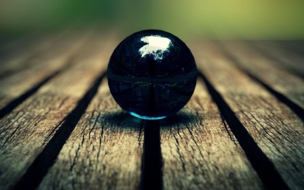 blue marble ball in focus on a wooden floor nature