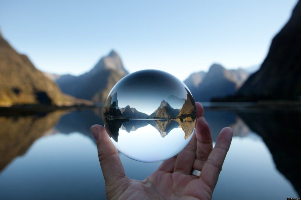 seize the moment Man holding crystal ball in landscape