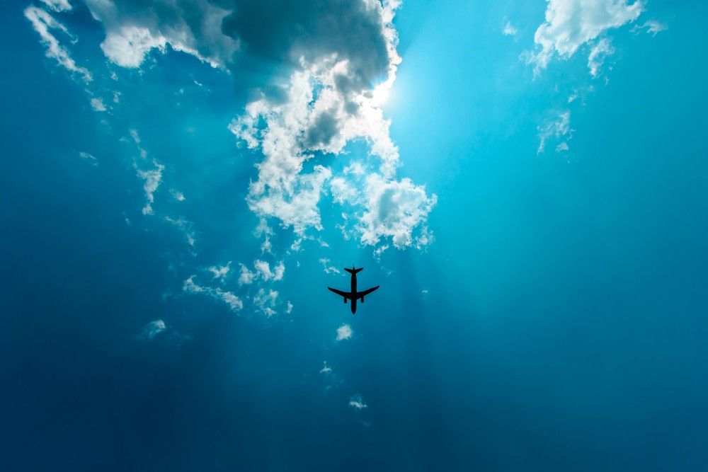 Flugzeug im Flug gegen einen blauen Schlitten