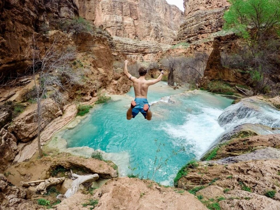 man-taking-leap-faith-jumping-off-cliff