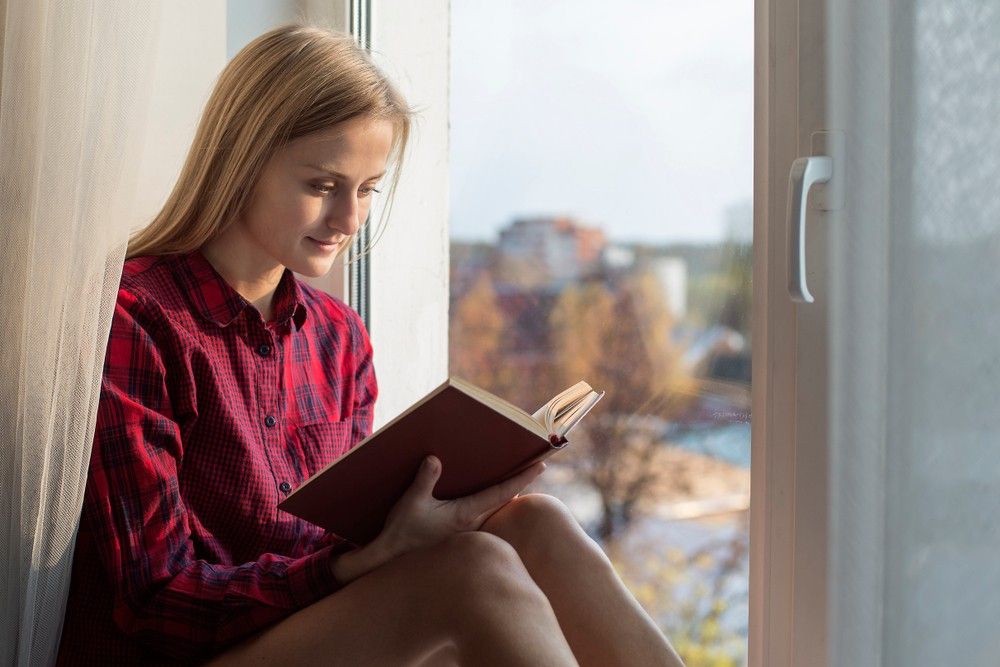 woman-sitting-by-window-journaling