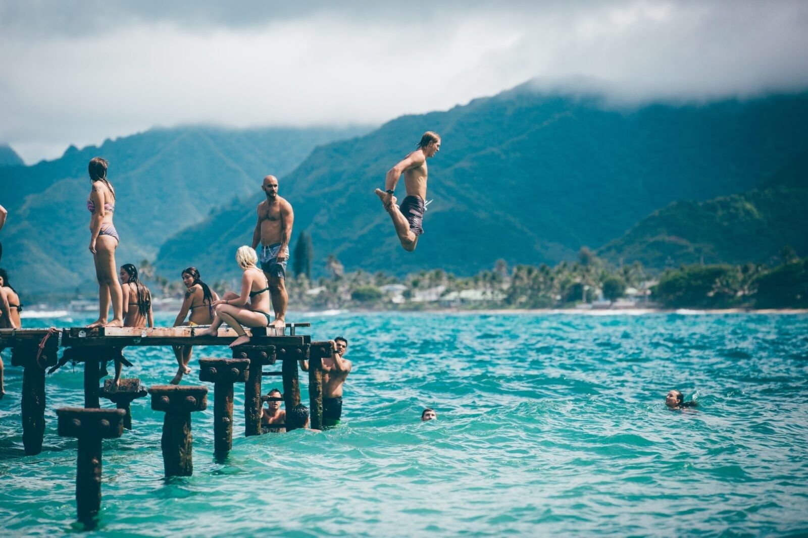 man-jumping-into-lake-surrounded-friends