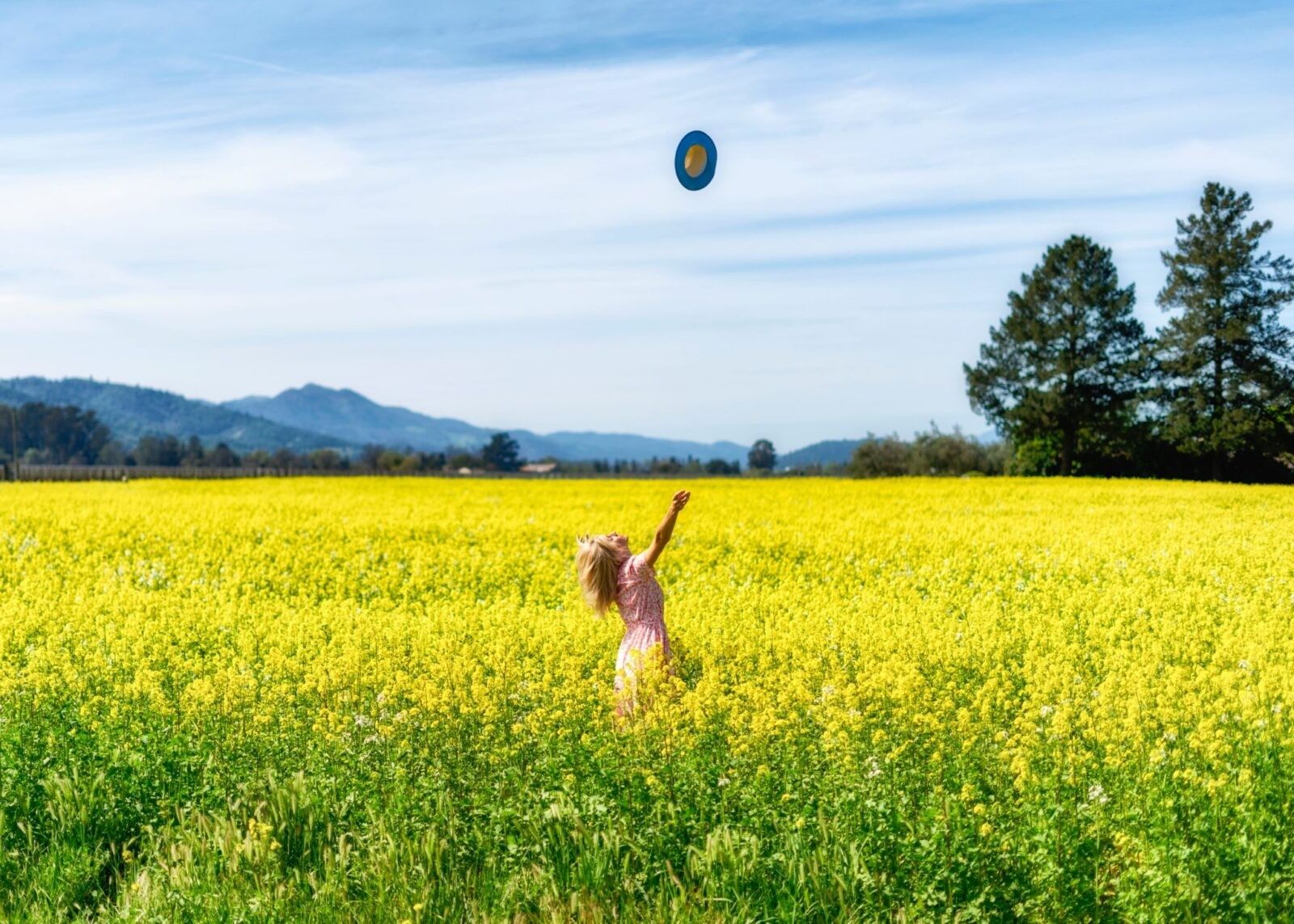 woman-throwing-hat-yellow-field