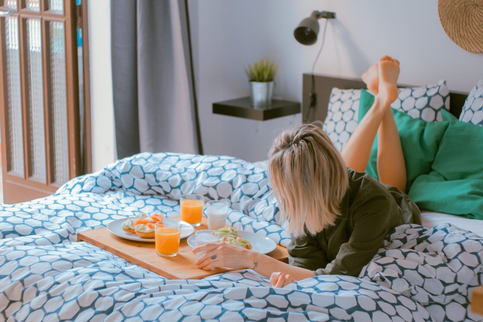 Woman-laying-on-bed-with-breakfast