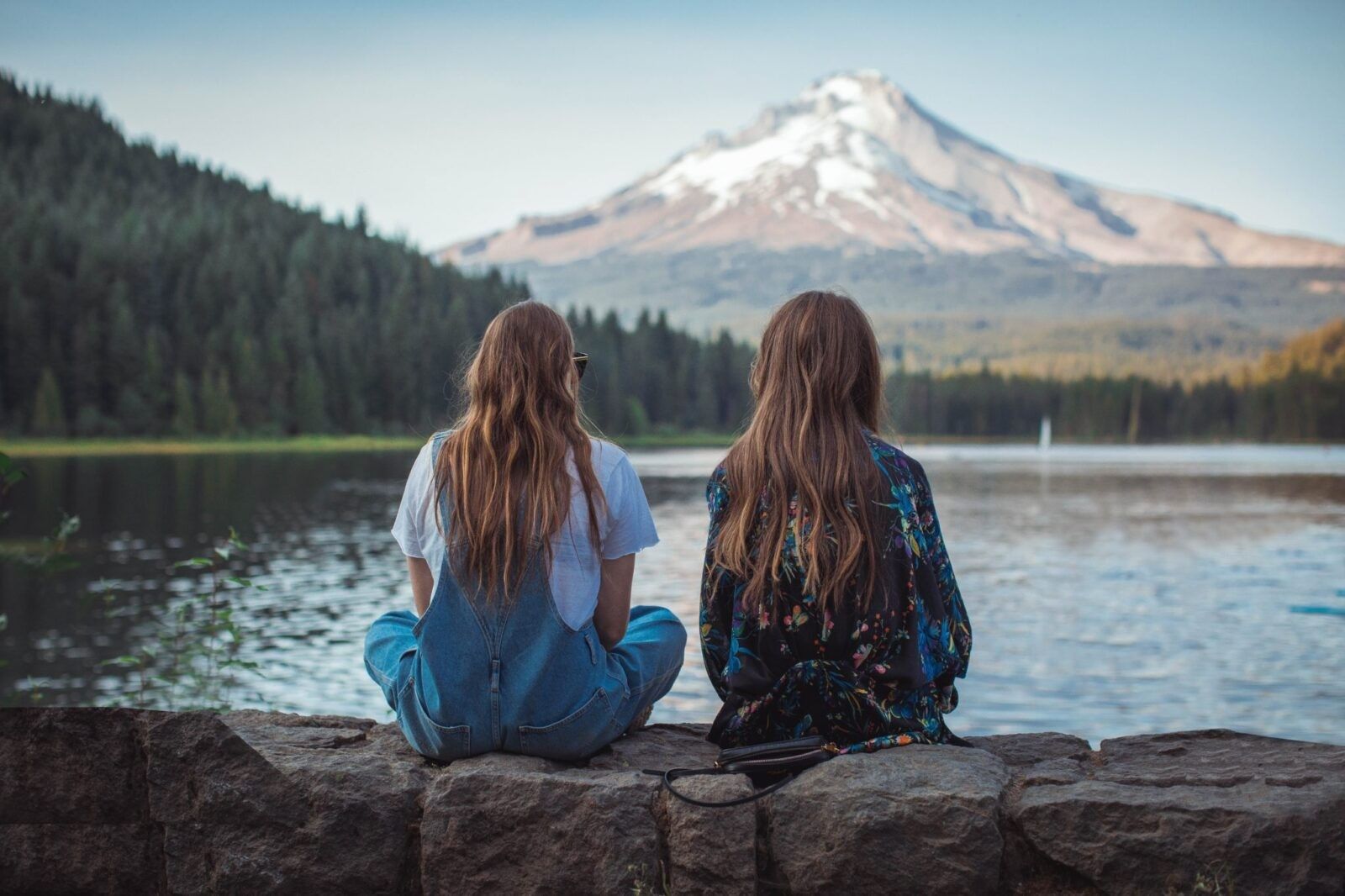 Two-girls-sitting-at-a-lake