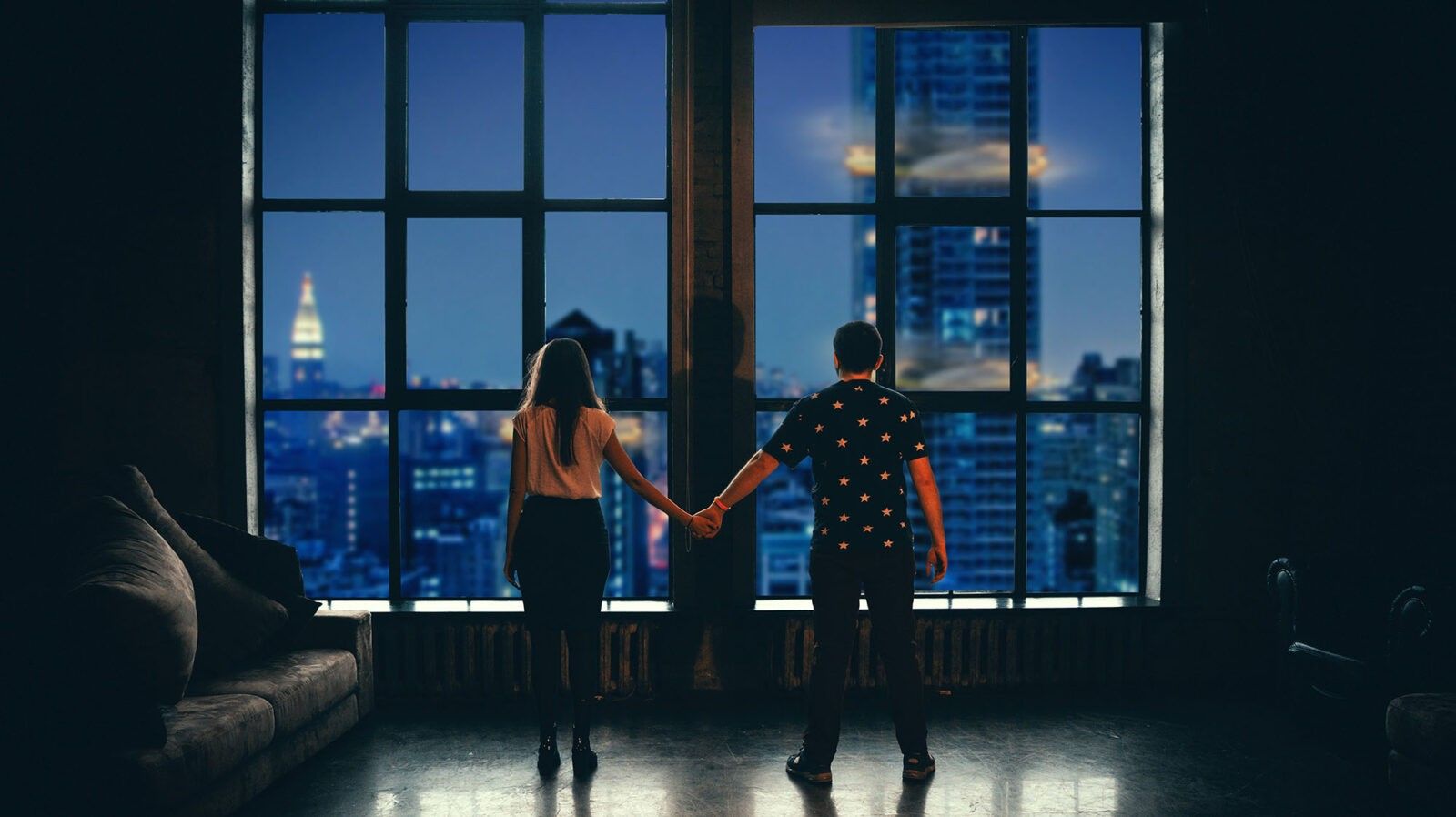 Couple in front of window holding hands