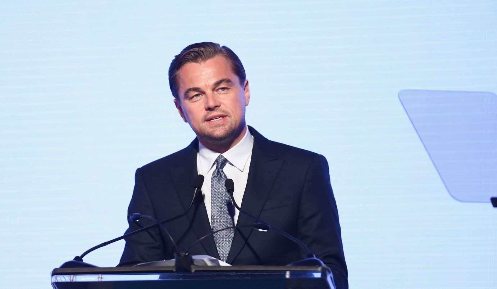 Leonardo DiCaprio in blue suit giving a speech on climate change