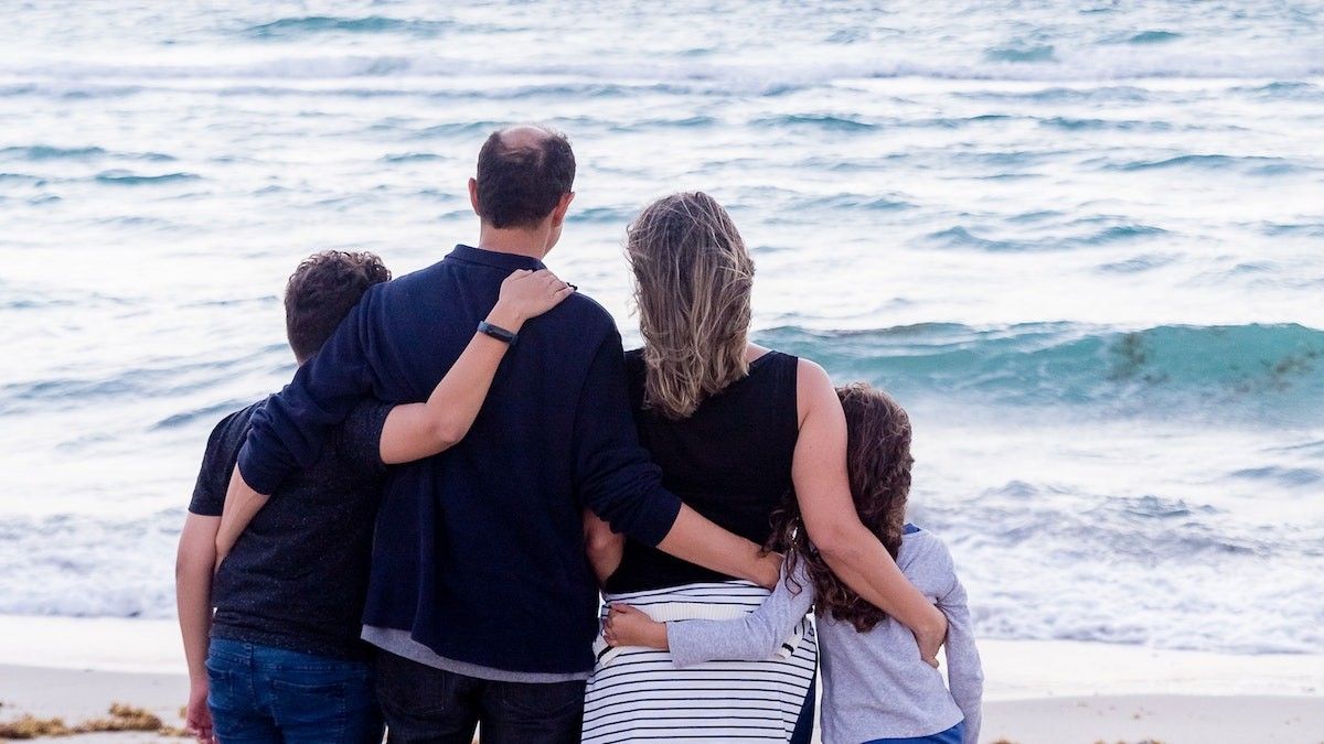 Family standing at the beach looking at the sea
