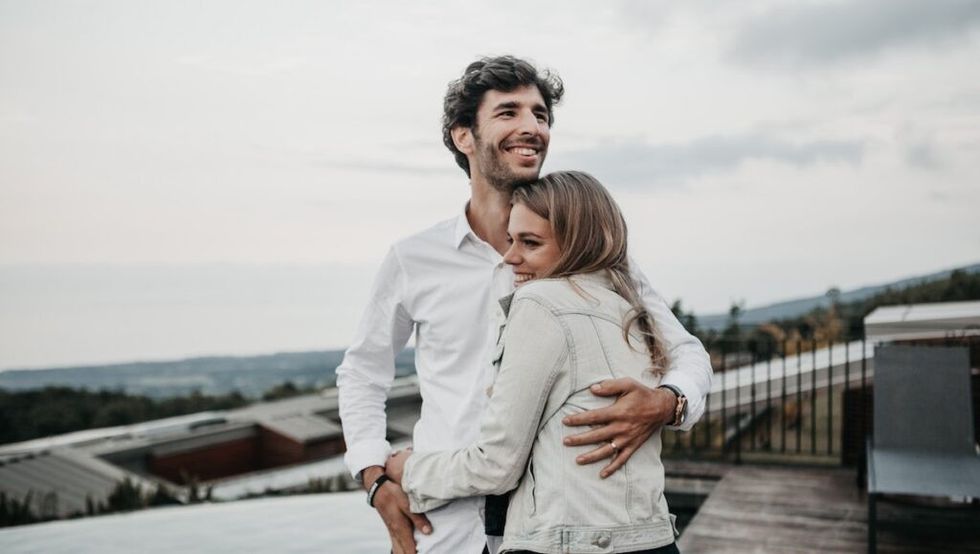 Man and woman smiling, hugging