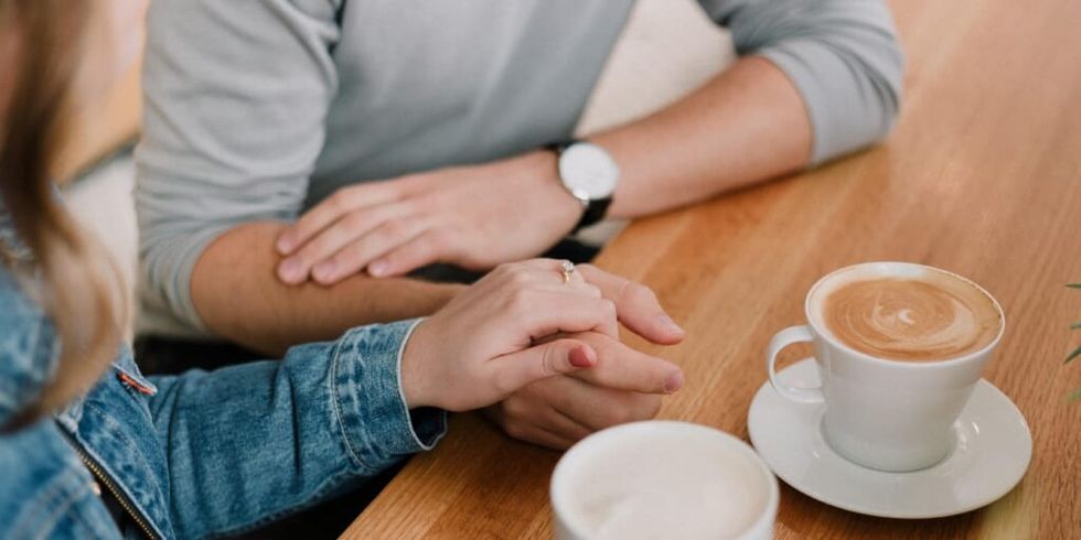 Man and woman holding hands while having coffee by Priscilla du Preez on Unsplash
