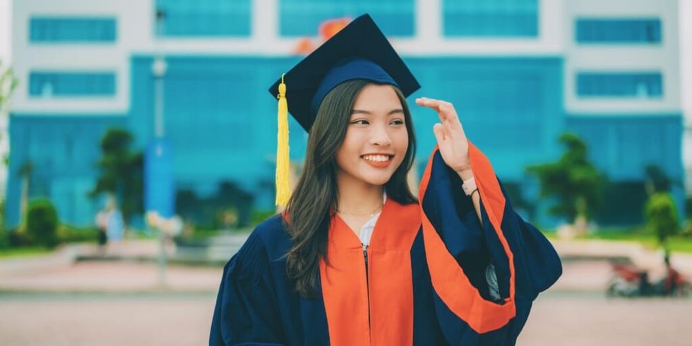 Girl smiling wearing graduation cap and robe by Tri Vo on Unsplash