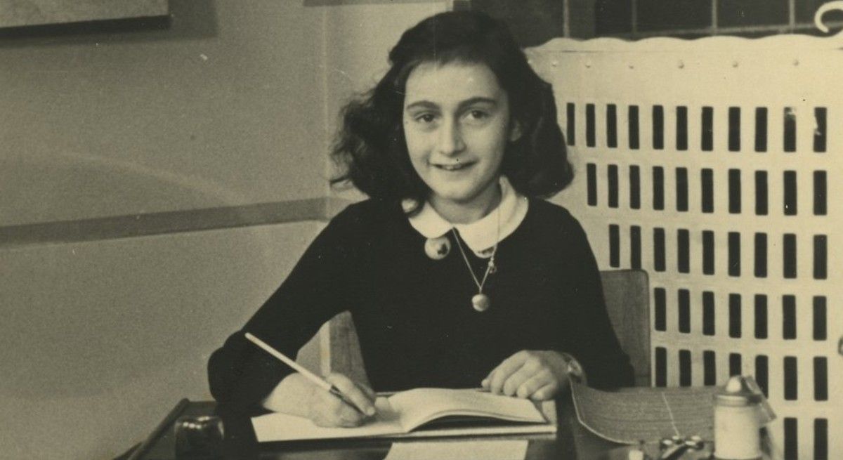 Anne Frank studying at her school desk.