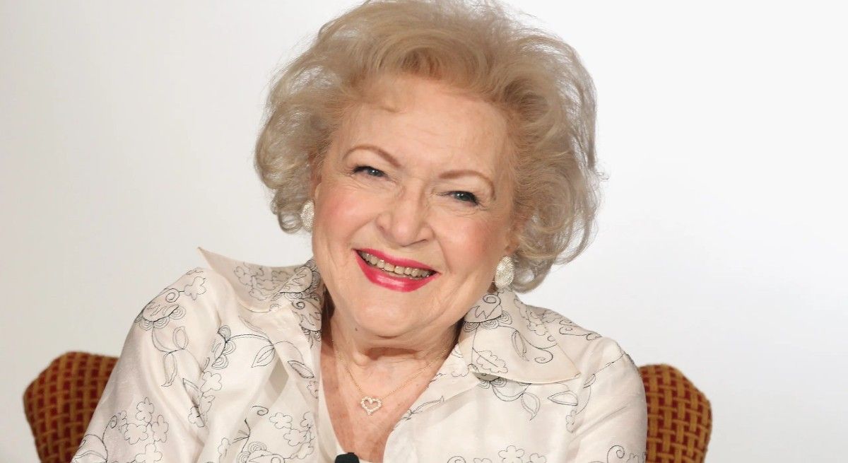 Betty White wearing a white blouse and smiling at the camera.