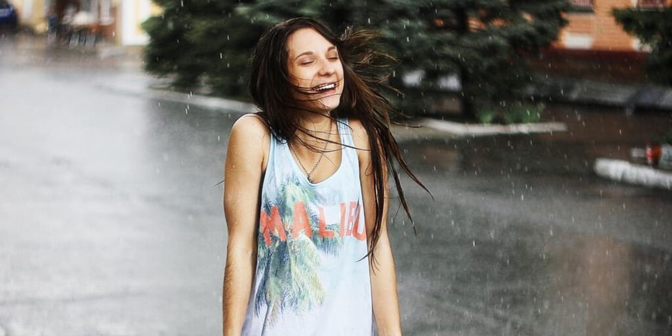 Woman smiling in the rain by Max Okhrimenko on Unsplash