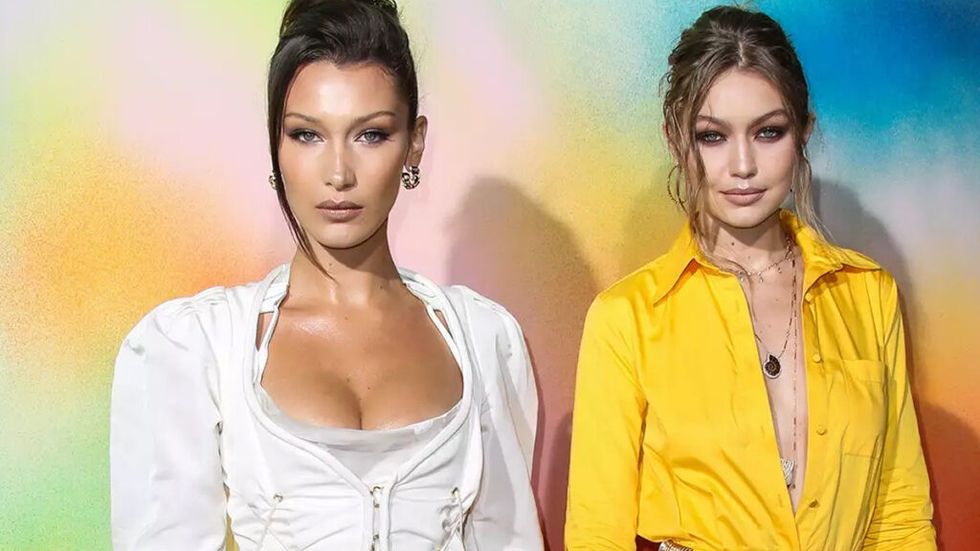 Bella and Gigi Hadid posing in front of a rainbow wall backdrop