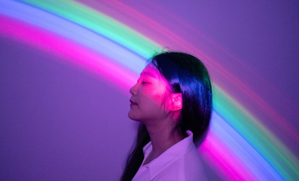 Junge asiatische Frau auf Regenbogenhintergrund
