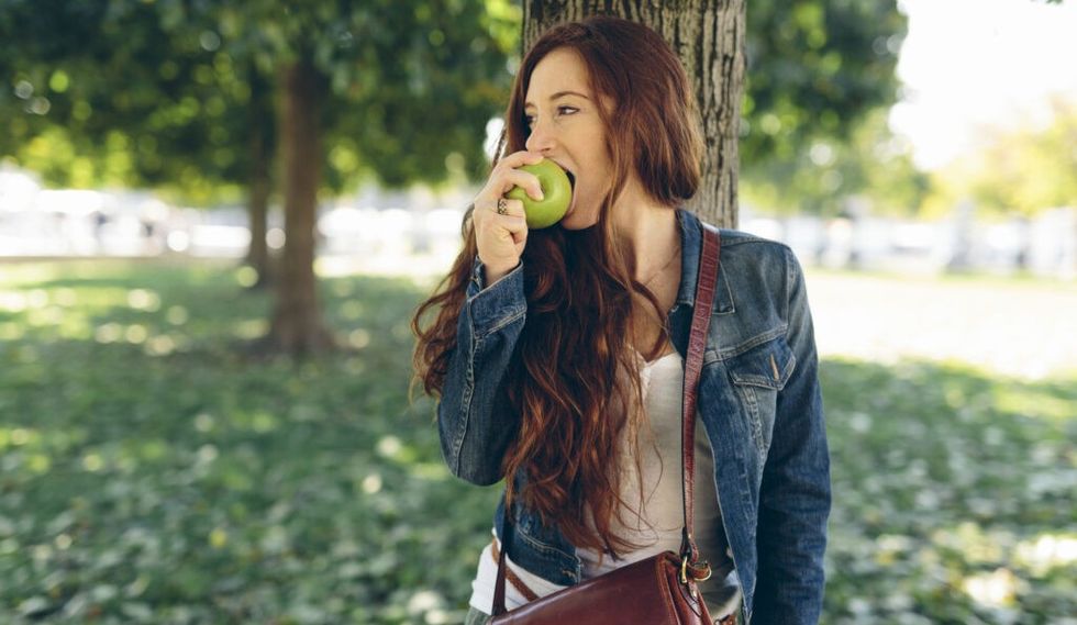 femeie care mănâncă un măr