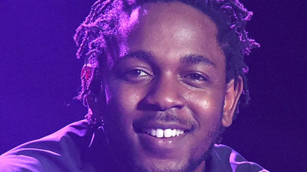 Kendrick Lamar smiling in a purple light