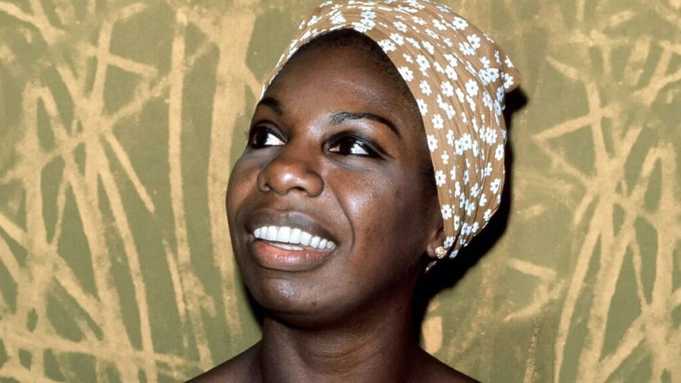 Nina Simone in a headwrap smiling
