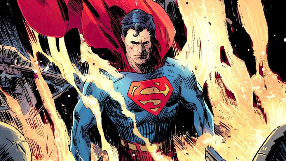 Superman surrounded by smoke with guns pointed at him looking stern