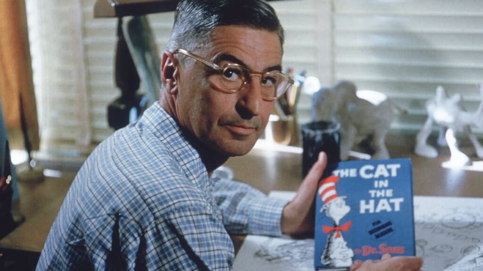 Dr. Seuss holding a copy of Cat in the Hat