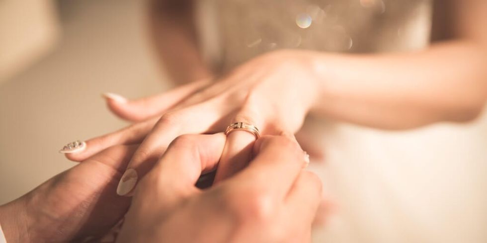 Groom placing ring on bride's finger by Jeongim Kwon on Unsplash