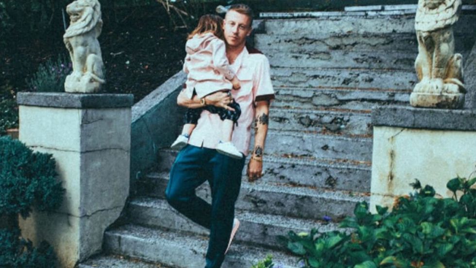 Macklemore carrying his daughter