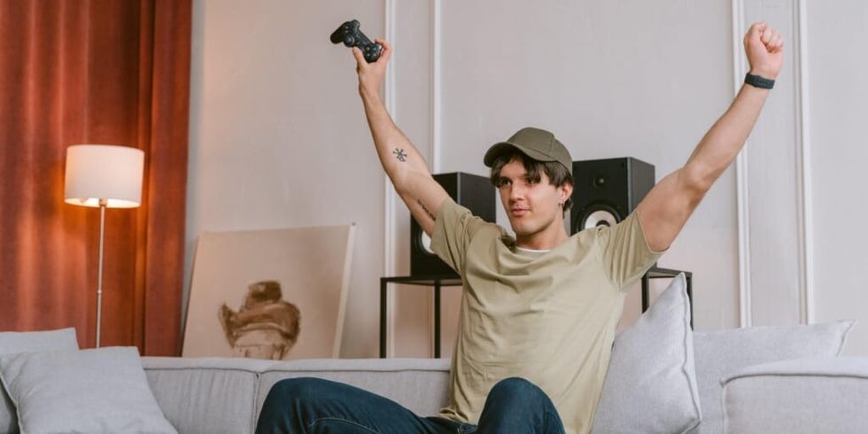 Man raising arms victoriously while playing video game by Tima Miroshnichenko on Pexels