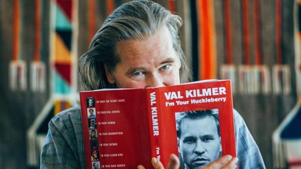 Val Kilmer with a copy of his book, I'm Your Huckleberry