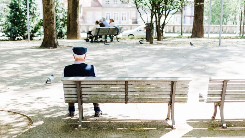 elderly man sitting alone on a bench