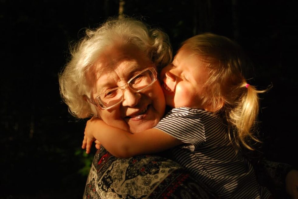 an elderly woman hugging a girl