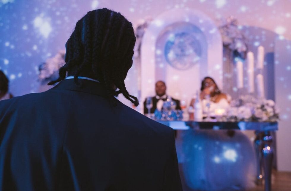 Man giving wedding speech facing bride and groom