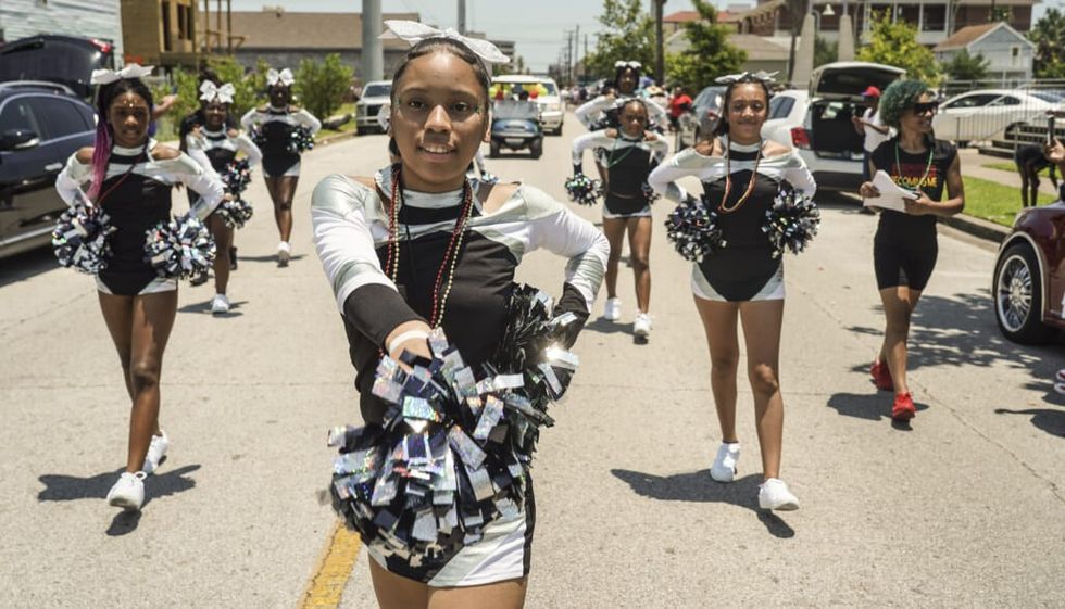 Young cheerleaders march during Juneteenth Parade