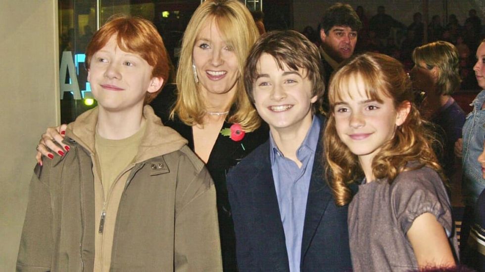JK Rowling posing with the Harry Potter movie cast