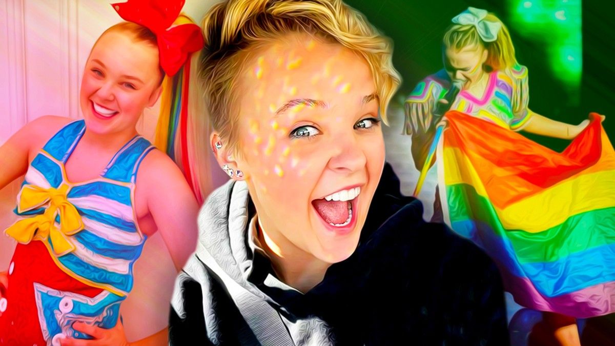 JoJo Siwa smiling in front of a rainbow flag