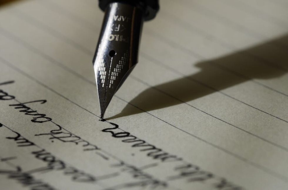 old fashioned pen writing cursive on paper