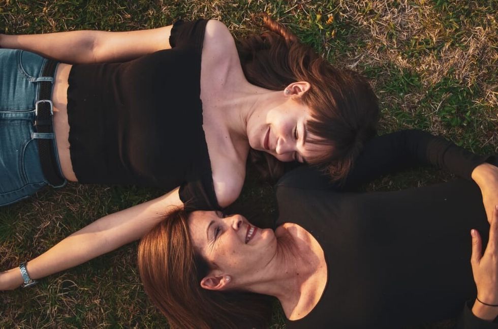 two women make eye contact lying down