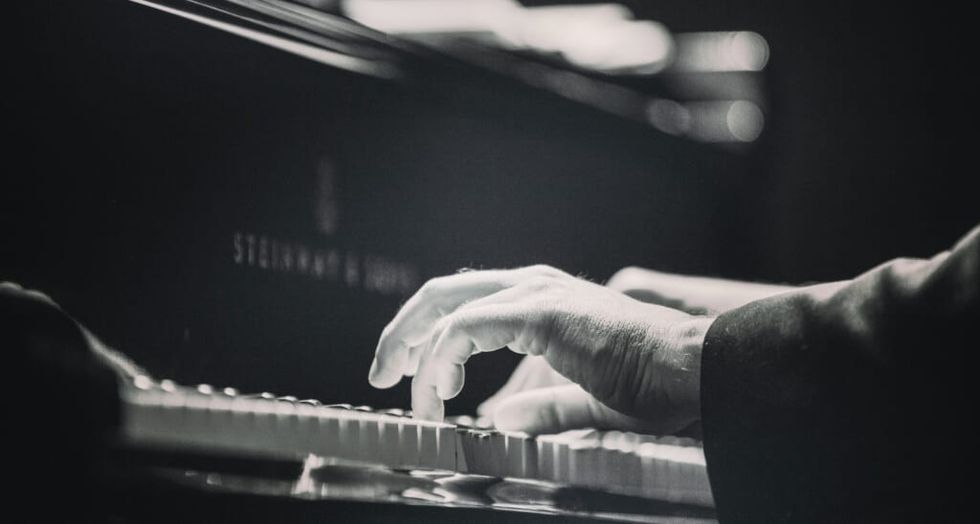 mâna cântând la pian alb-negru