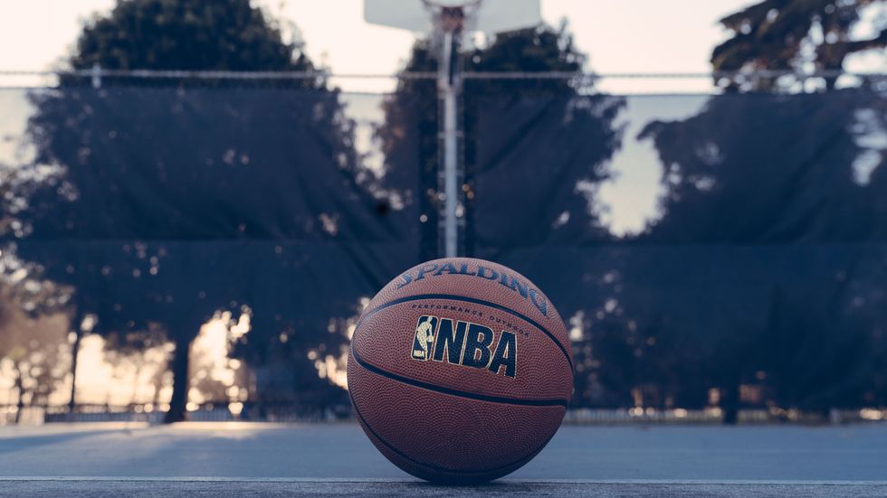 a ball with "NBA" on it sitting on a basketball court