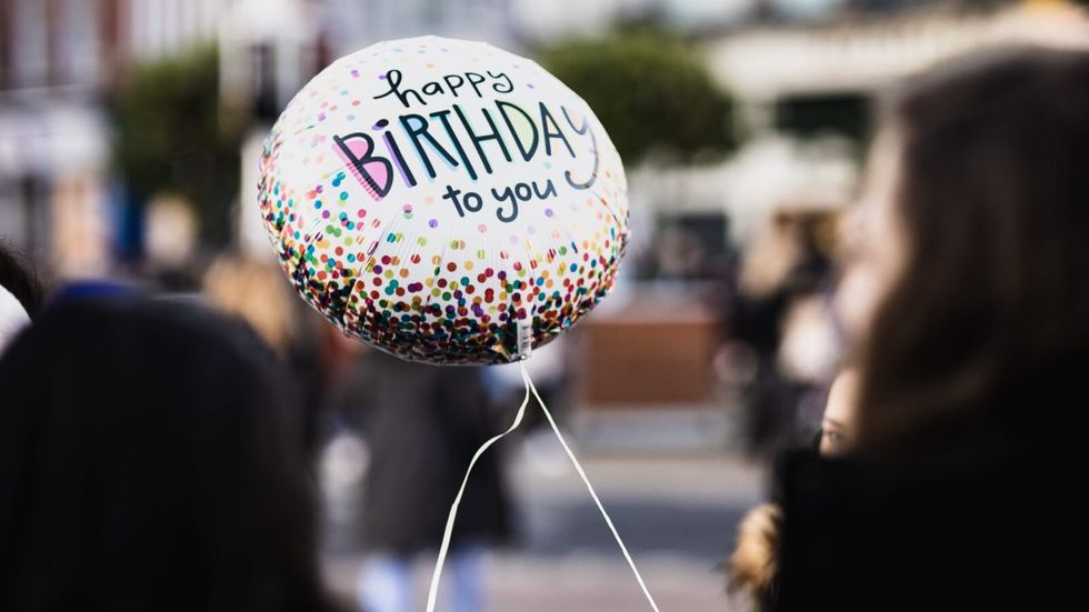 person holding a birthday balloon