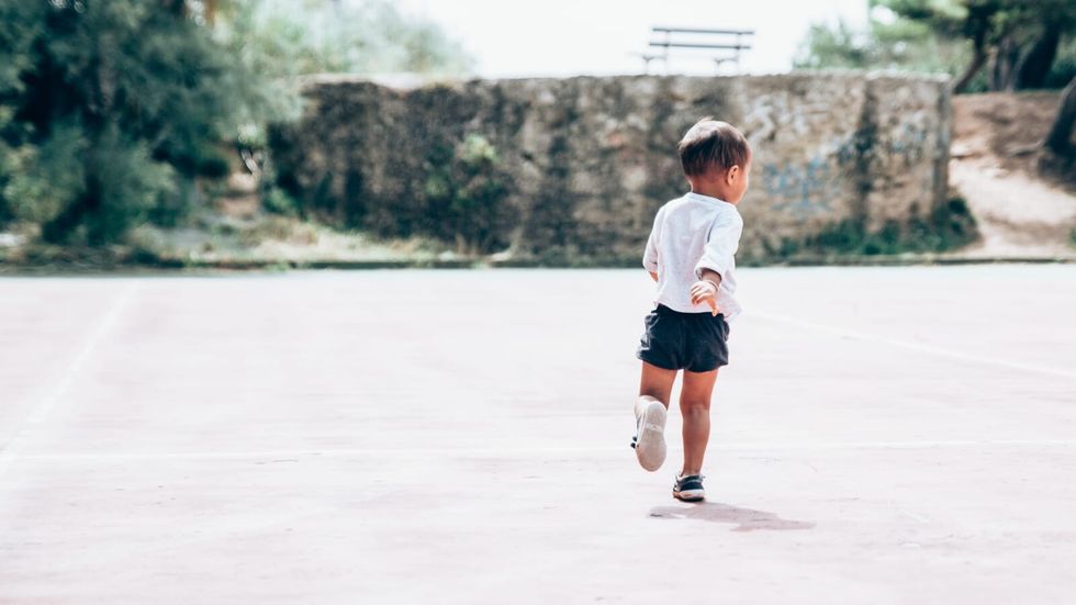 toddler running on an empty playground