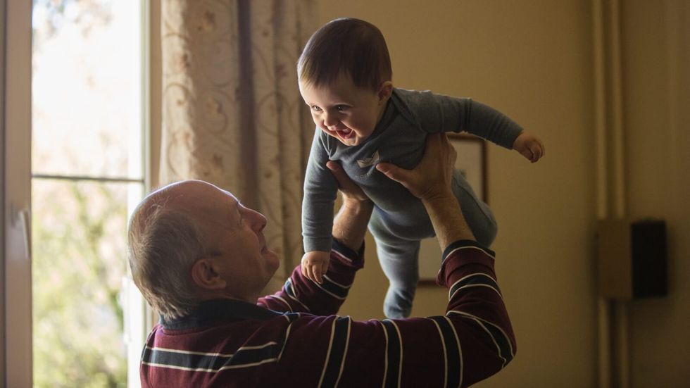 elderly man holding a baby