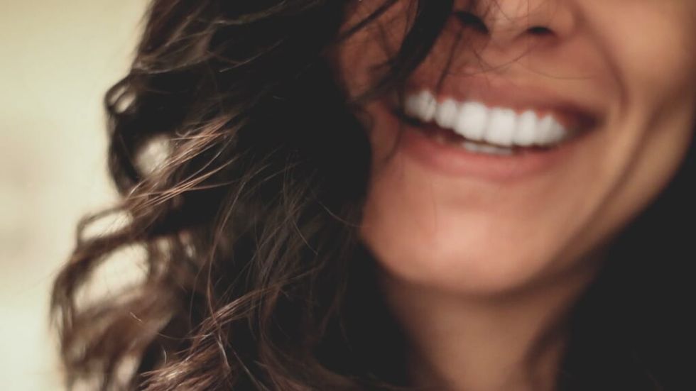 femeie zâmbind dinți albi