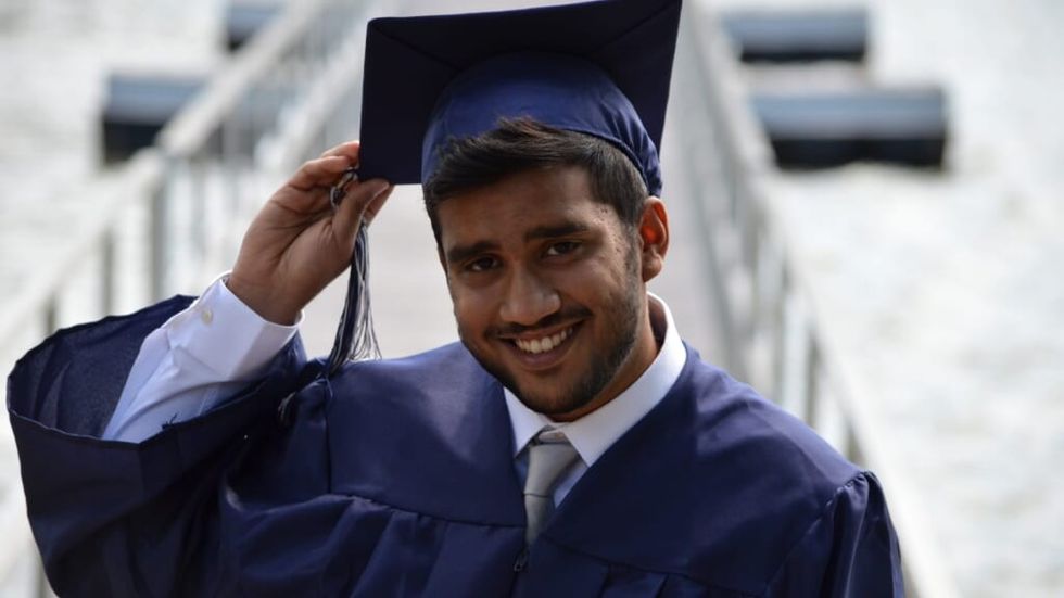 man holding graduation cap on his head