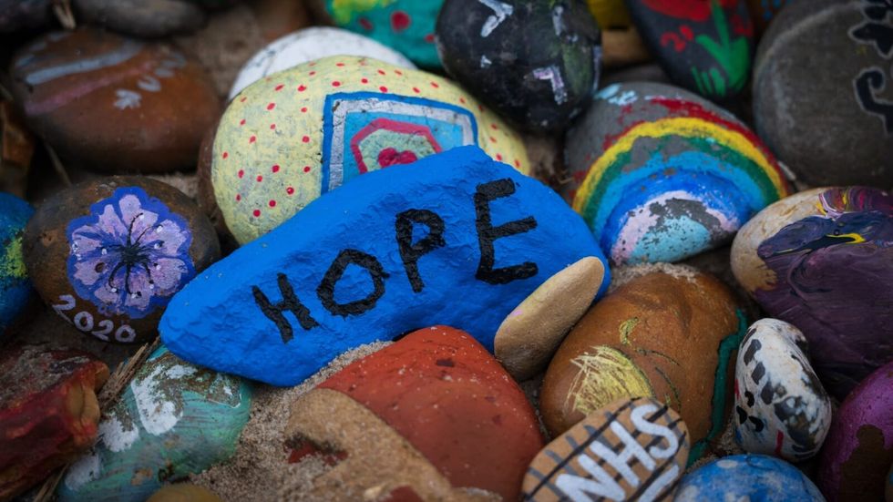 "hope" written on a blue stone surrounded by colorful stones