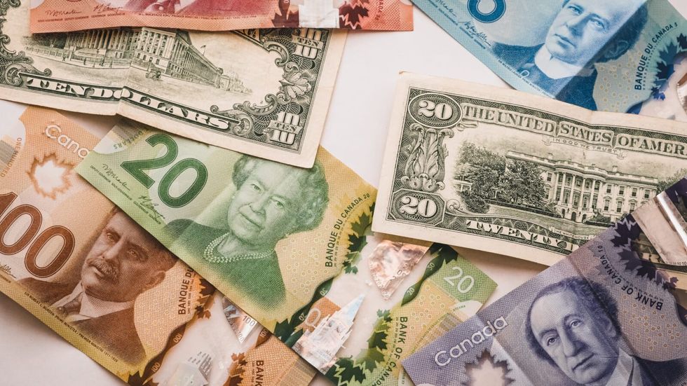 Canadian and US dollars on a white surface