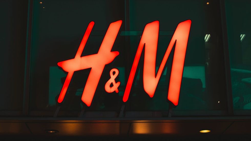 large neon red H&M sign against a dark background
